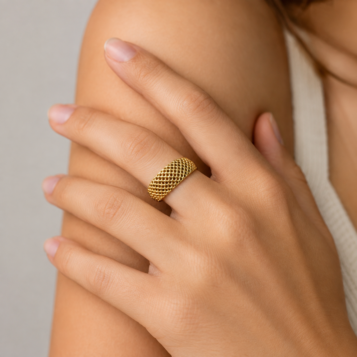 Anillos Elegantes en Oro 10K de TuOro® con diseño texturizado, puestos en la mano de una mujer joven en foto de estilo catálogo.