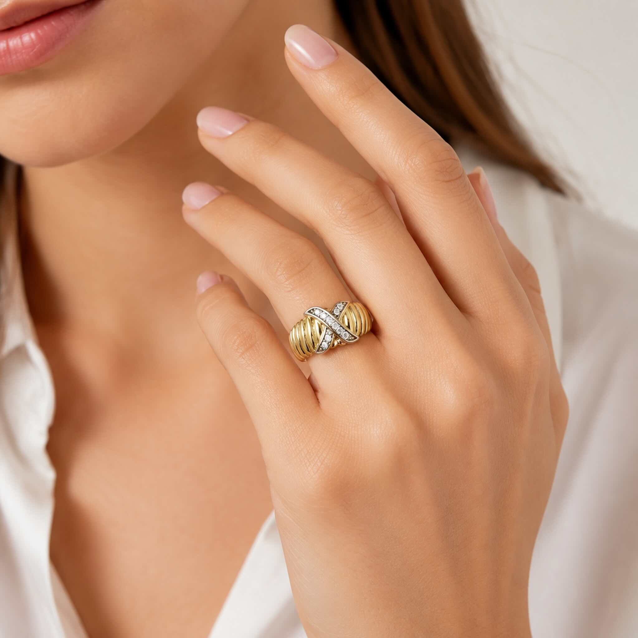 Anillo elegante en Oro 10K con diseño cruzado y circonias blancas, lucido en la mano de una mujer joven en foto de catálogo TuOro®.