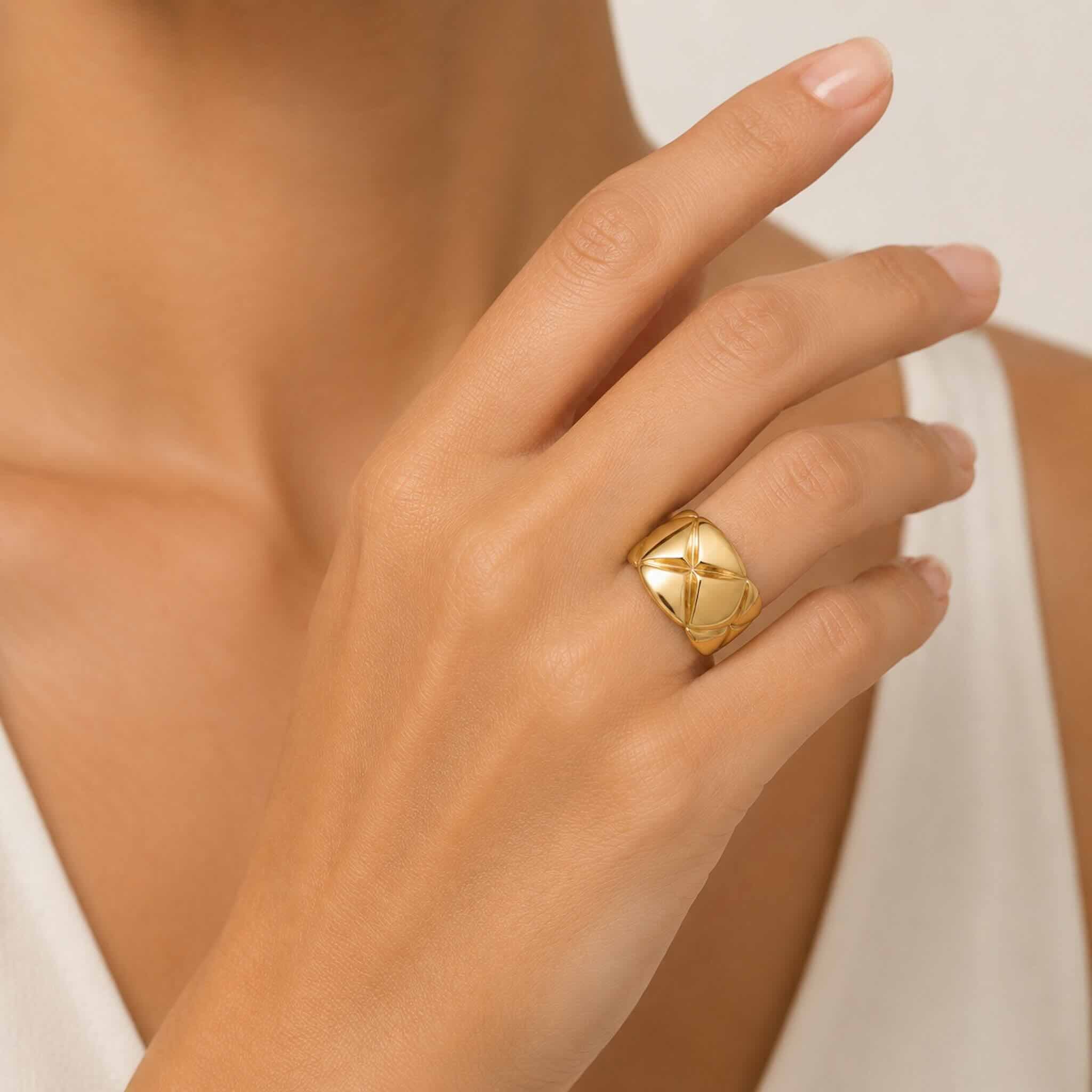 Anillo llamativo en Oro 10K con galería y diseño geométrico en relieve, puesto en la mano de una mujer elegante, TuOro®.