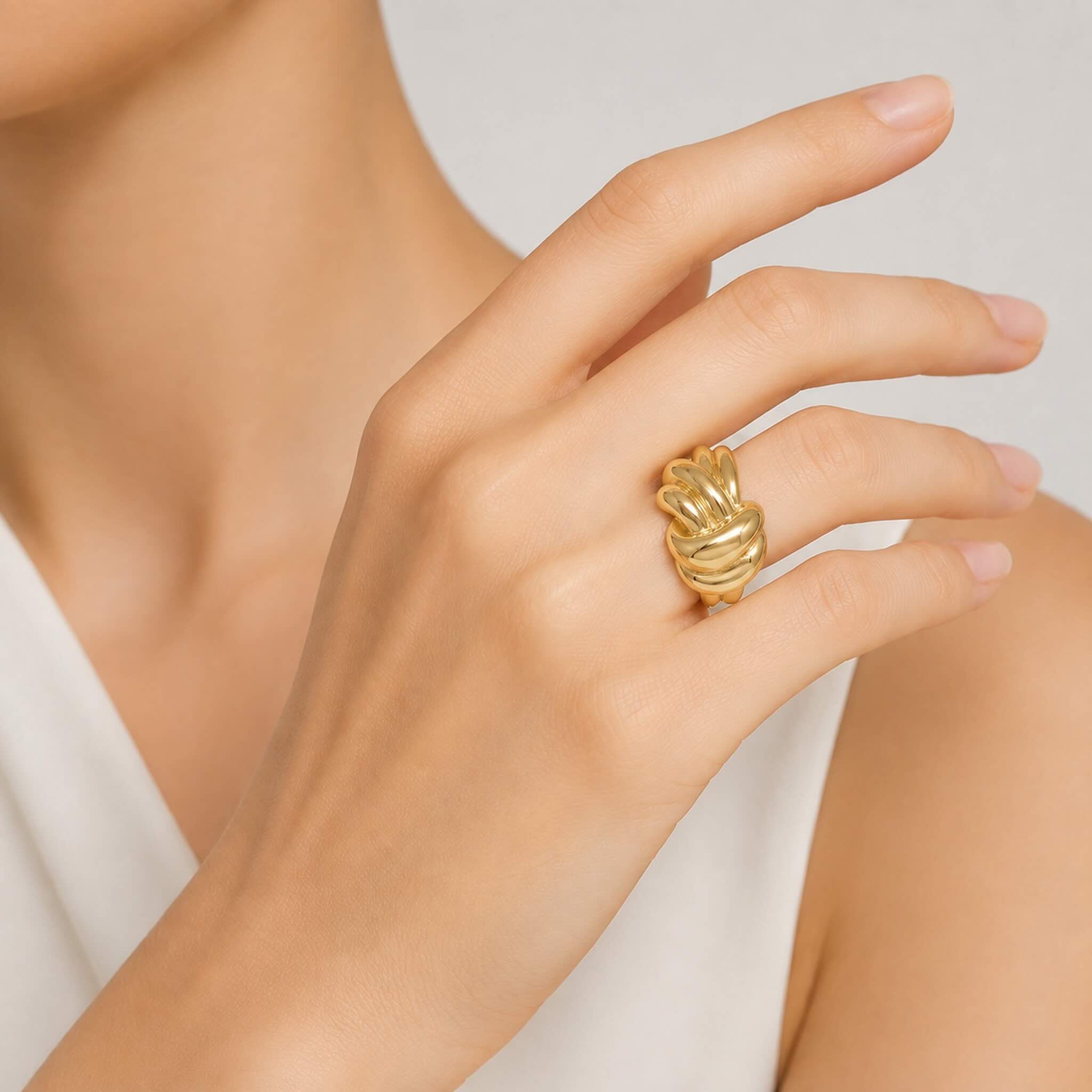 Anillo llamativo en Oro 10K con galería y diseño de nudo escultural pulido, lucido en la mano de una mujer, TuOro®.