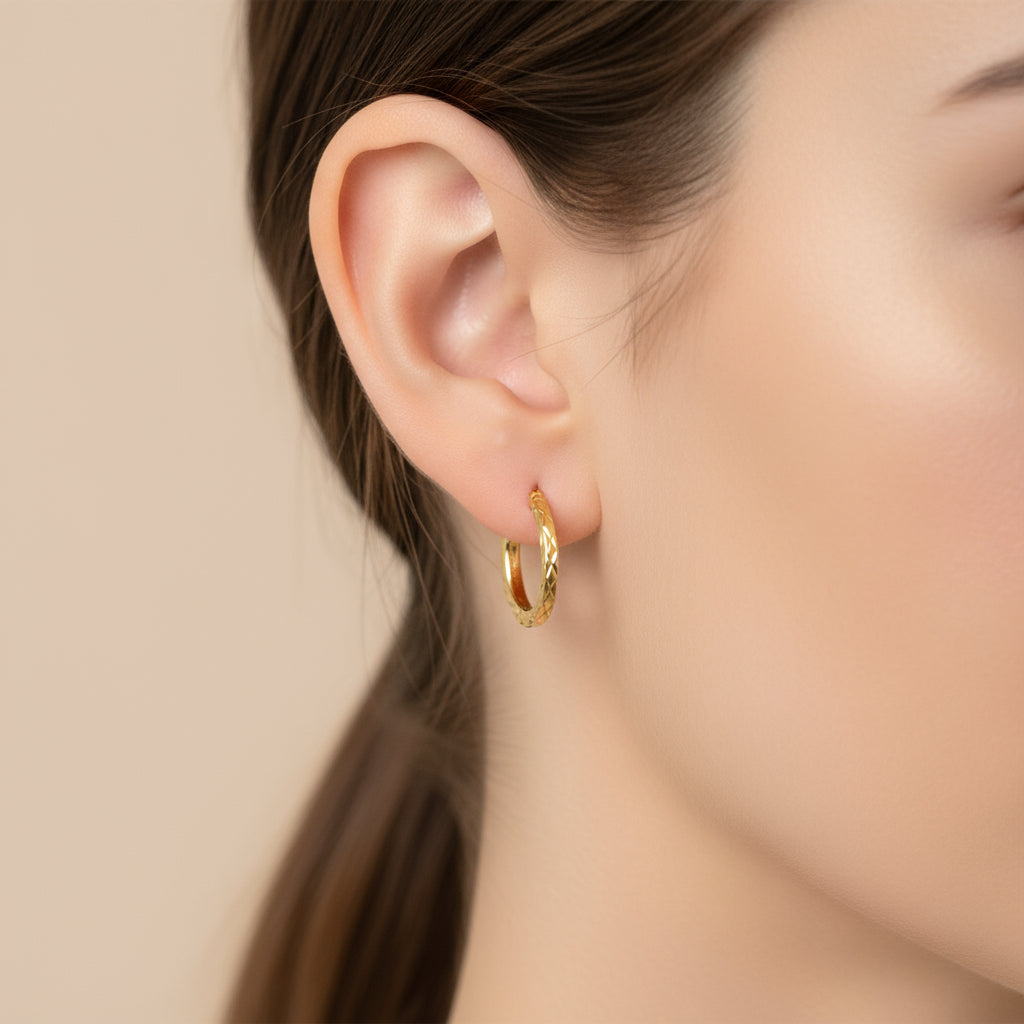 Arete argollita para niños en oro 14K, diseño texturizado con acabado en relieve. usada por modelo, TuOro.