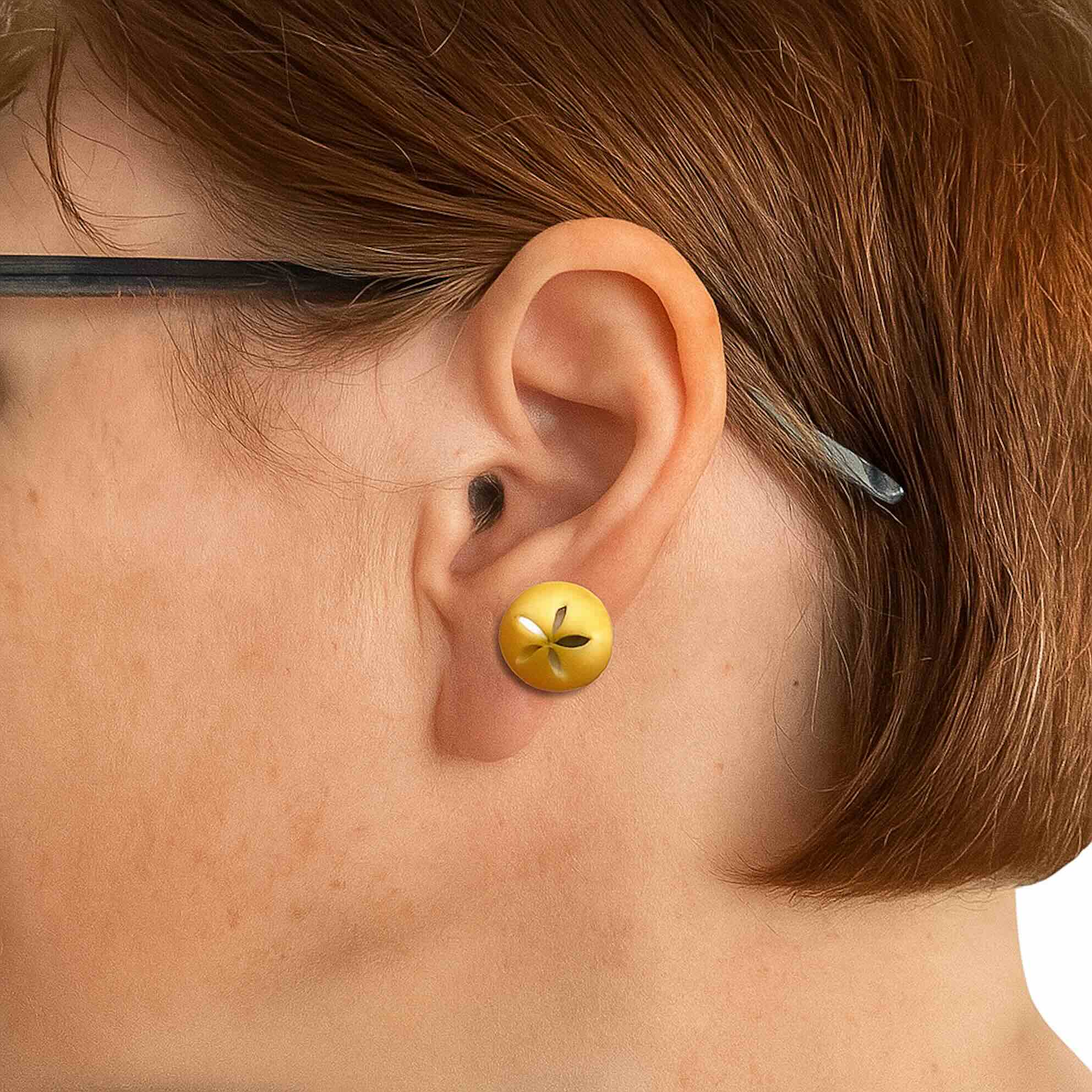 Arete de oro 14K con diseño de esfera satinada y grabado floral, mostrado puesto en oreja para referencia de tamaño