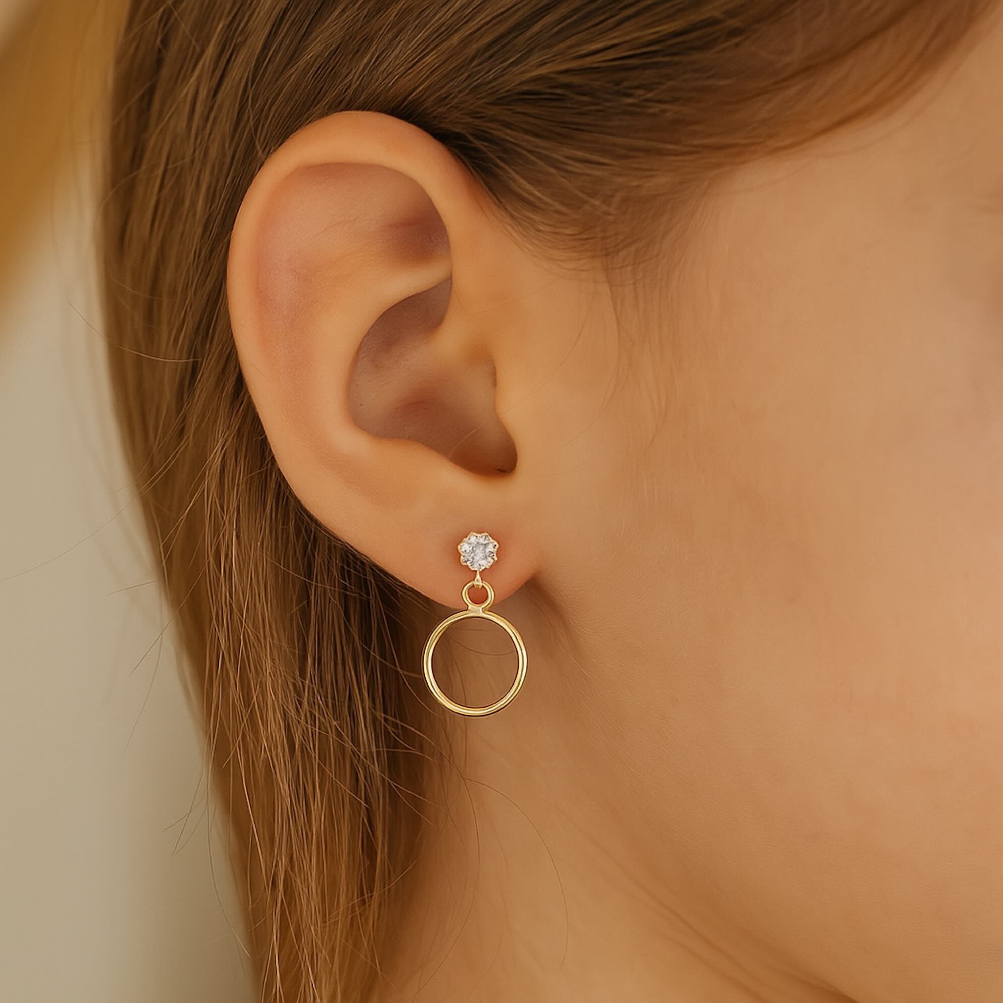 Mujer usando arete de oro 14K con cierre de rosca, diseño colgante de círculo liso y zirconia brillante, elegante y moderno.
