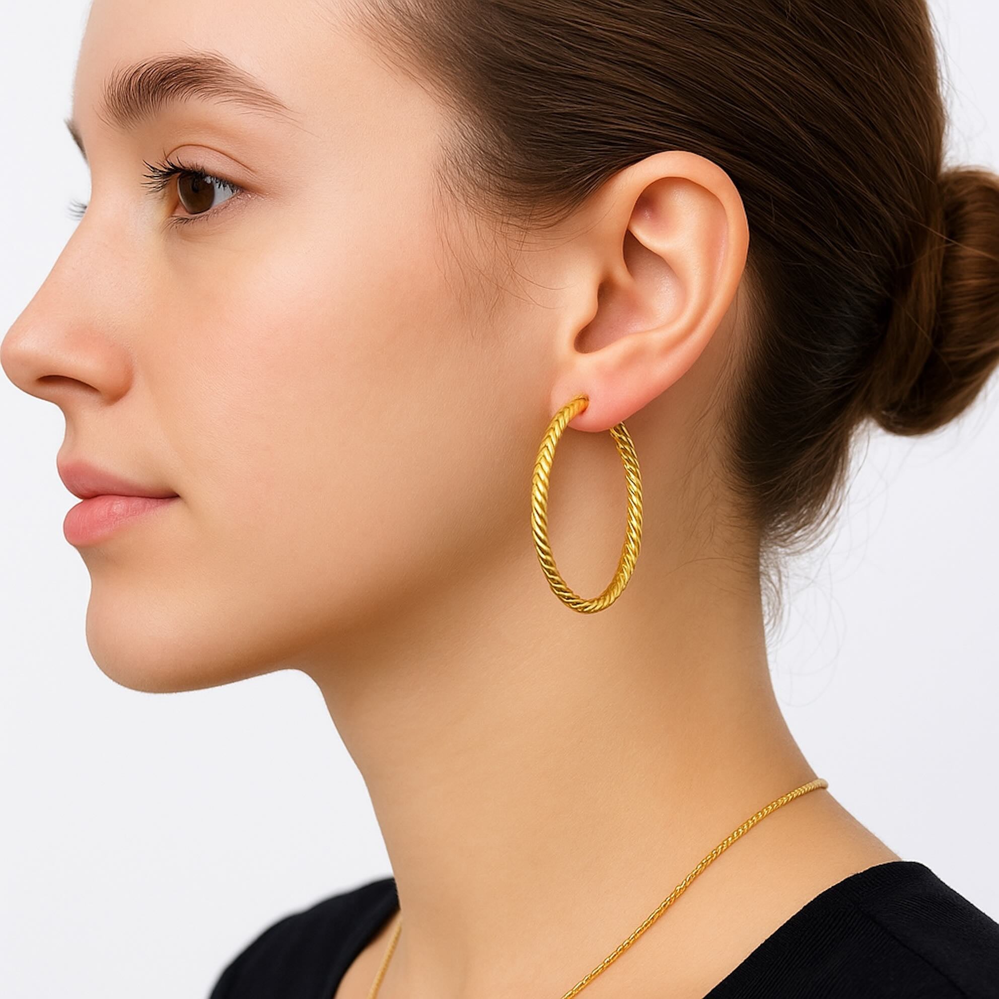 Modelo usando aretes argolla torcido en oro 14K grandes con diseño elegante estilo cuerda, perfectos para un look moderno y sofisticado.