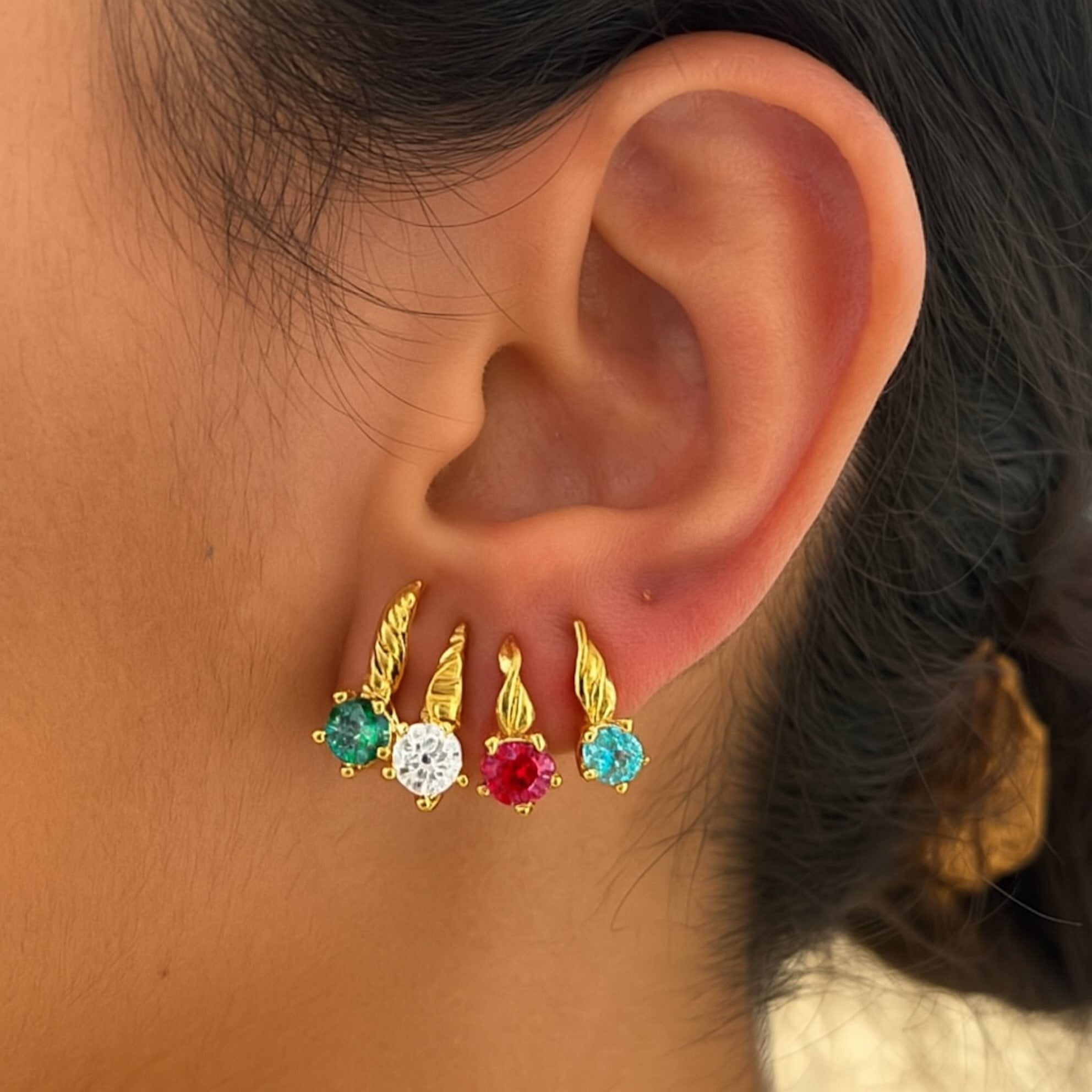 Aretes cortos en oro 14K con cierre de presión, montados en oreja real, con zirconias de colores: blanco, rojo, verde esmeralda y azul celeste, ideales para uso diario
