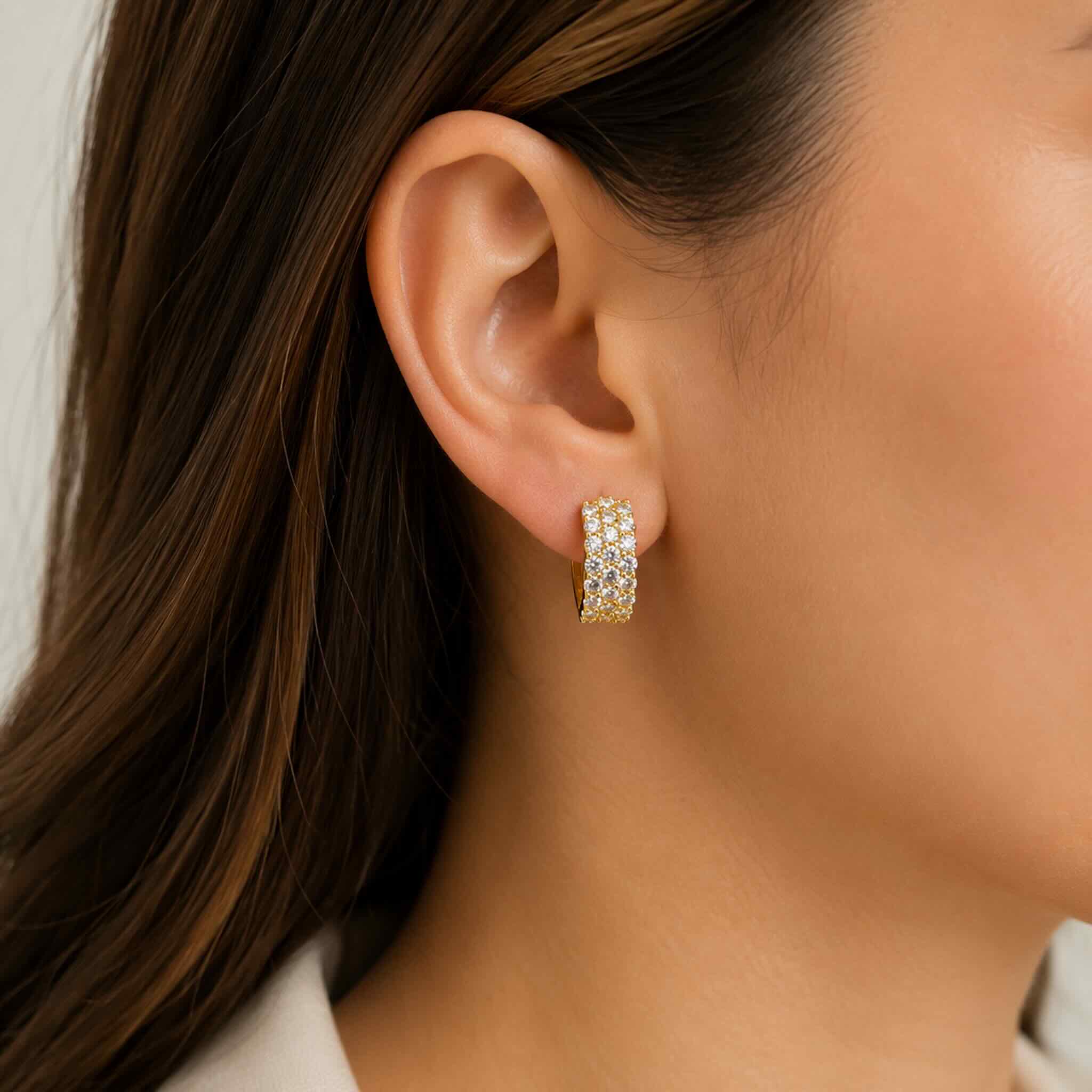 Modelo usando Aretes Huggie de Plata 925 dorada con piedras brillantes Mosainita, diseño elegante y moderno para uso diario, TuOro.