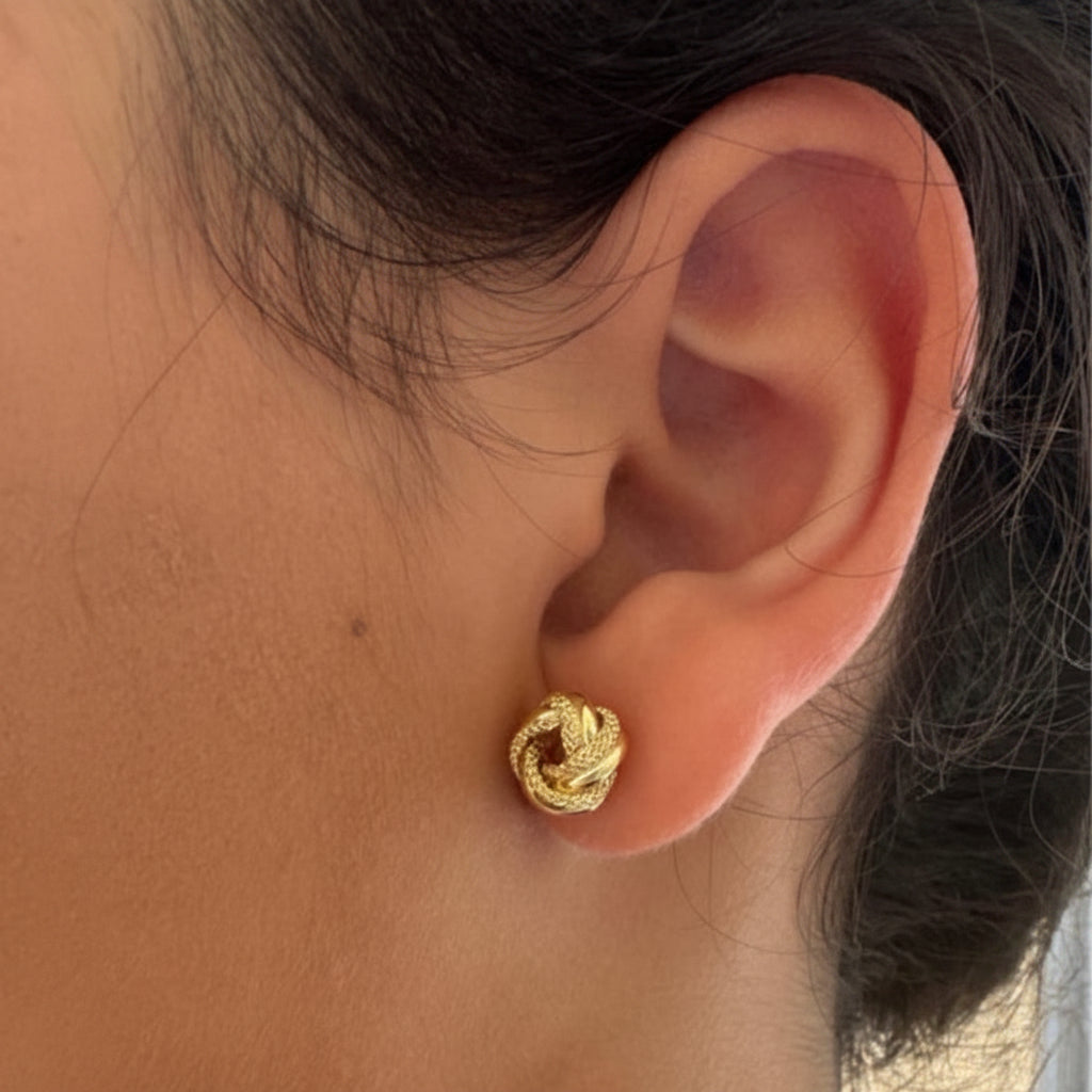 Aretes nudos del amor usados por una modelo en Oro 14K, 9 mm. TuOro.
