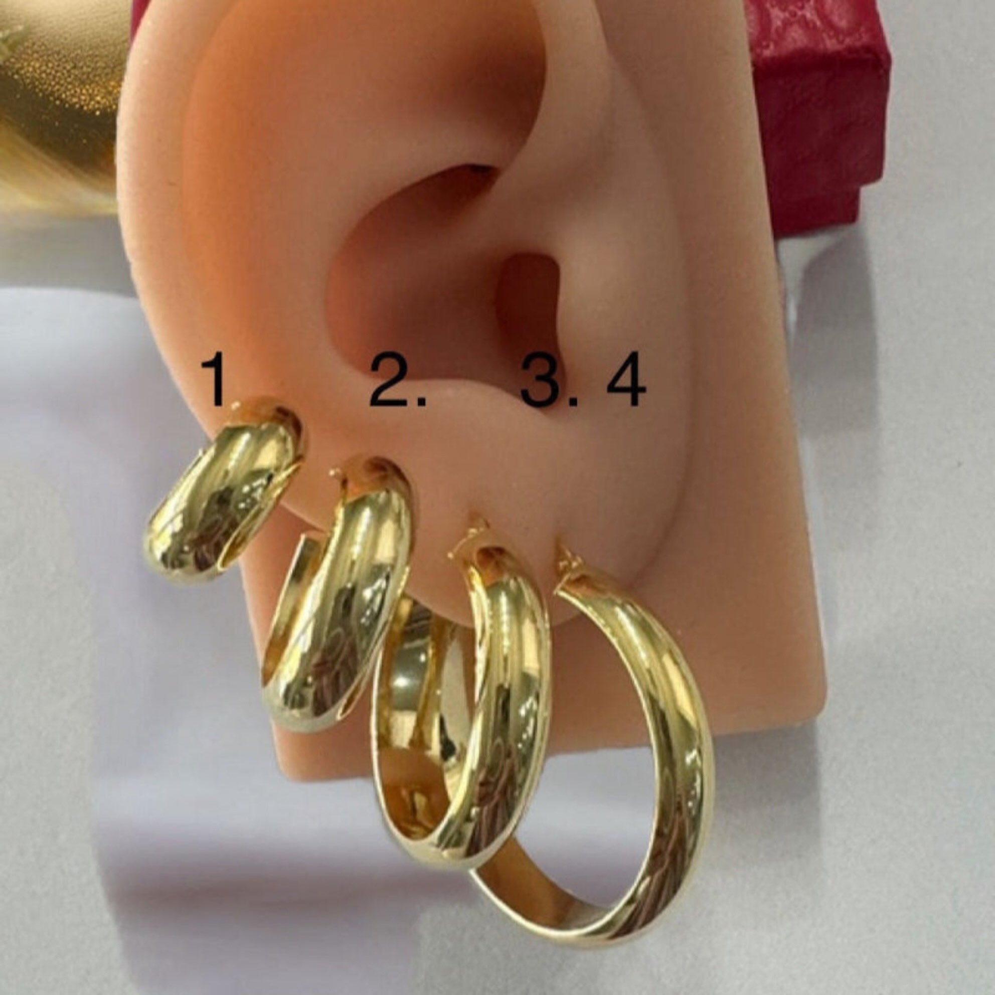 Comparación de tamaños de argollas lisas media caña en oro 14K en oreja de exhibición – Joyería TuOro