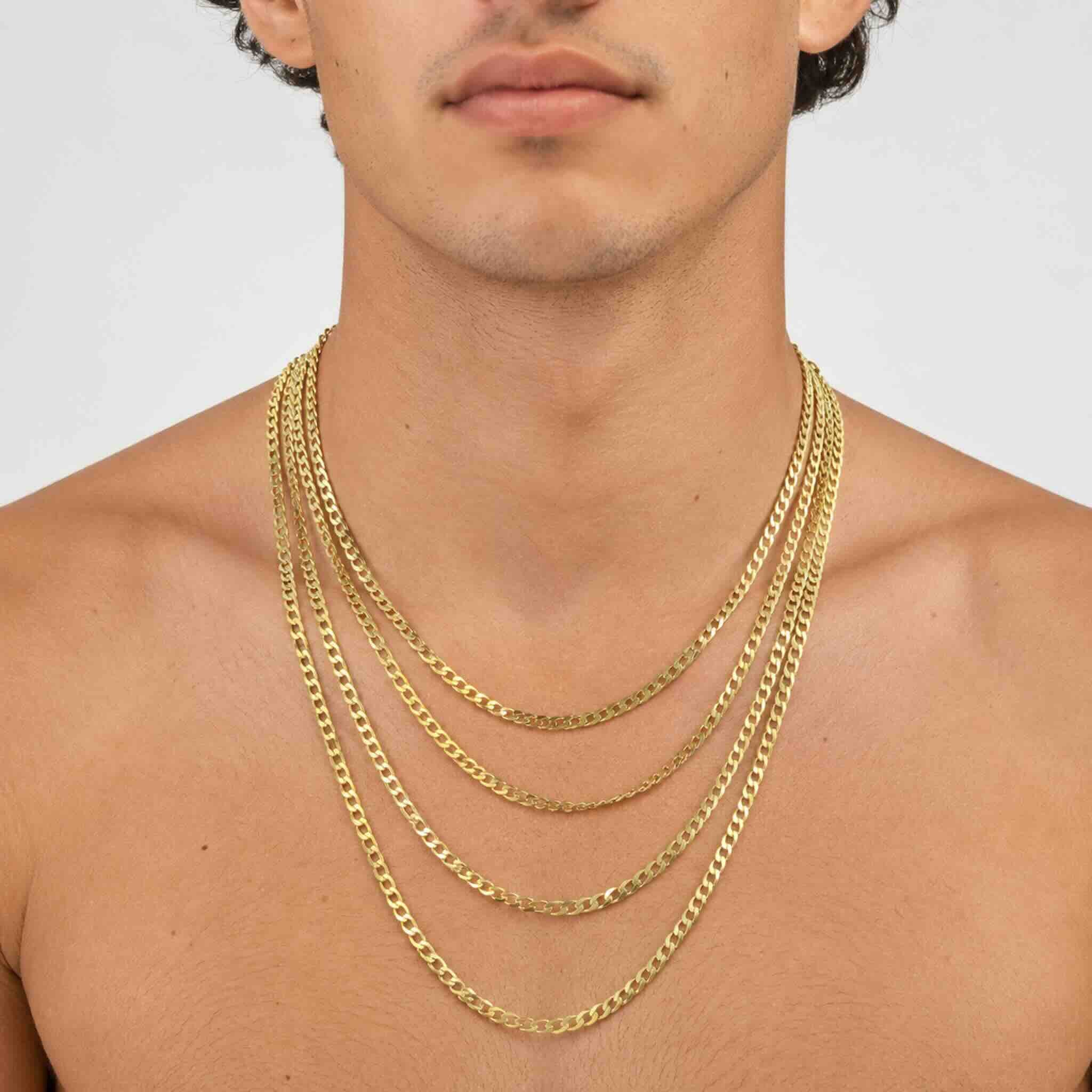 Cadenas cubanas de oro 10K de 4 mm en largos de 18 a 24 pulgadas sobre el cuello de un hombre joven.