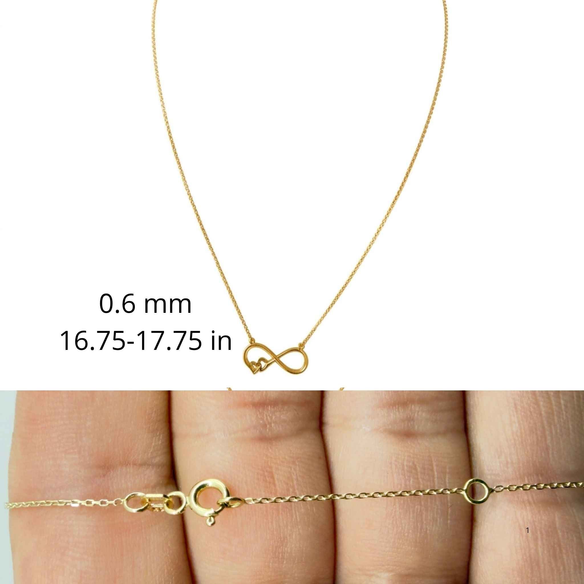 Cadena fina de oro 10K TuOro con dije de infinito y pequeño corazón, grosor de 0.6 mm, largo ajustable y detalle del cierre.