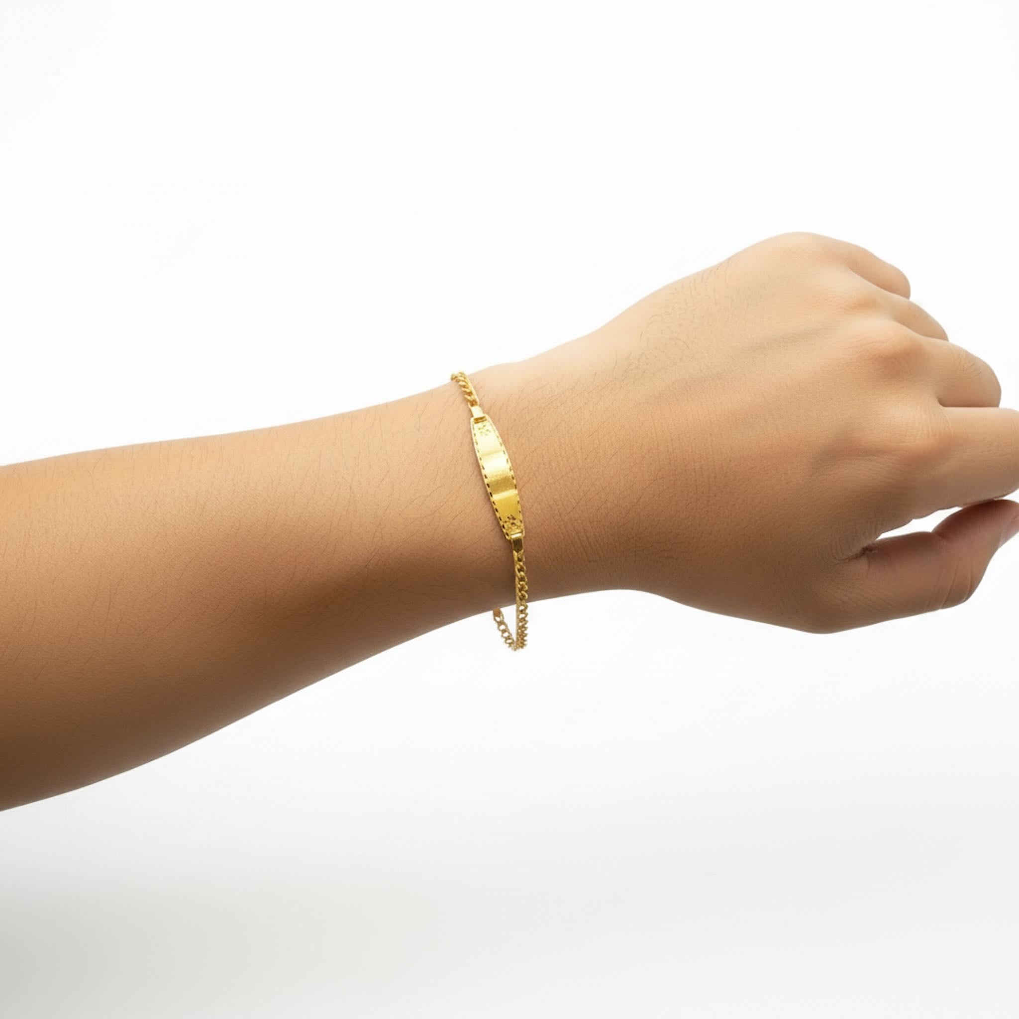 Pulsera de Oro 10K Amoro con placa lisa de 4 mm colocada en la muñeca — TuOro