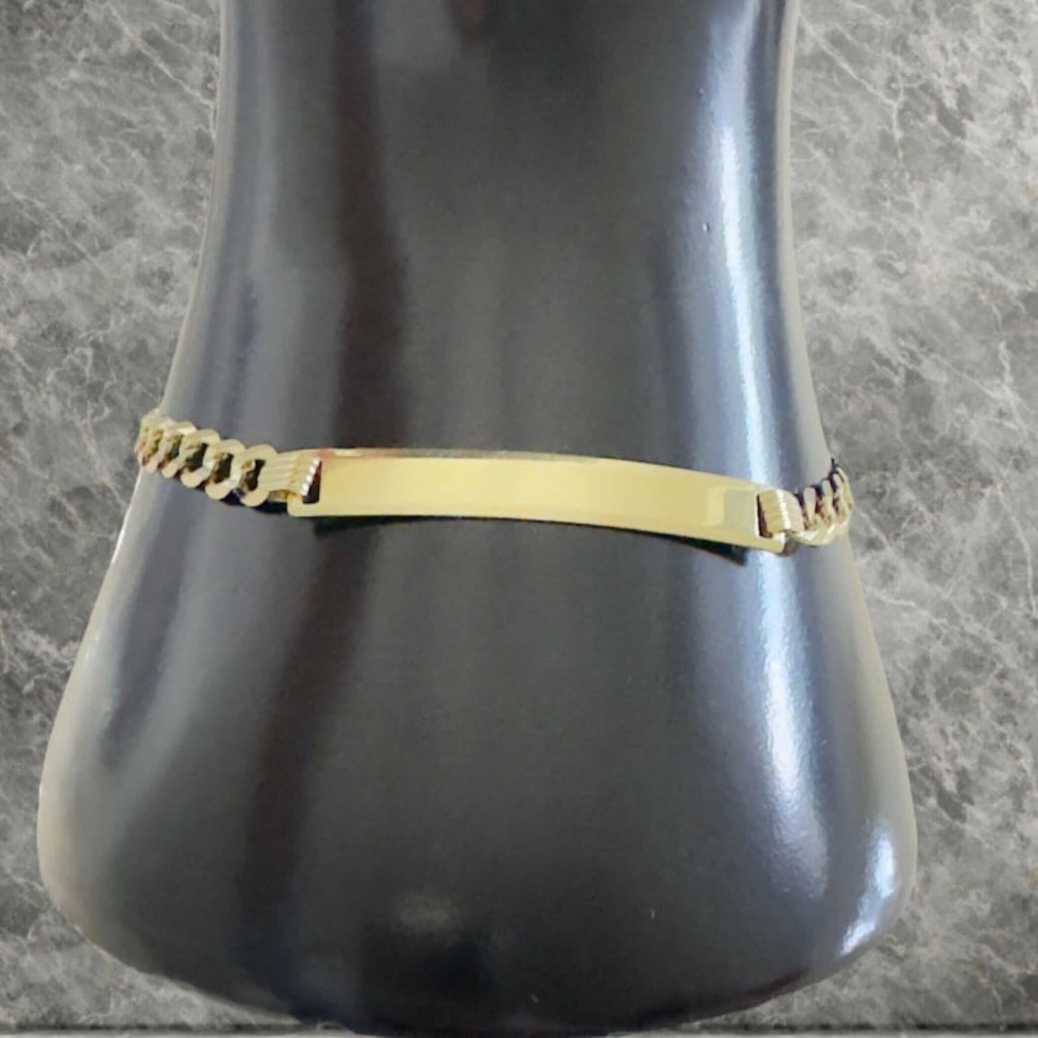 Pulsera cadena cubana italiana en Oro 14K con placa central colocada en la muñeca. TuOro.