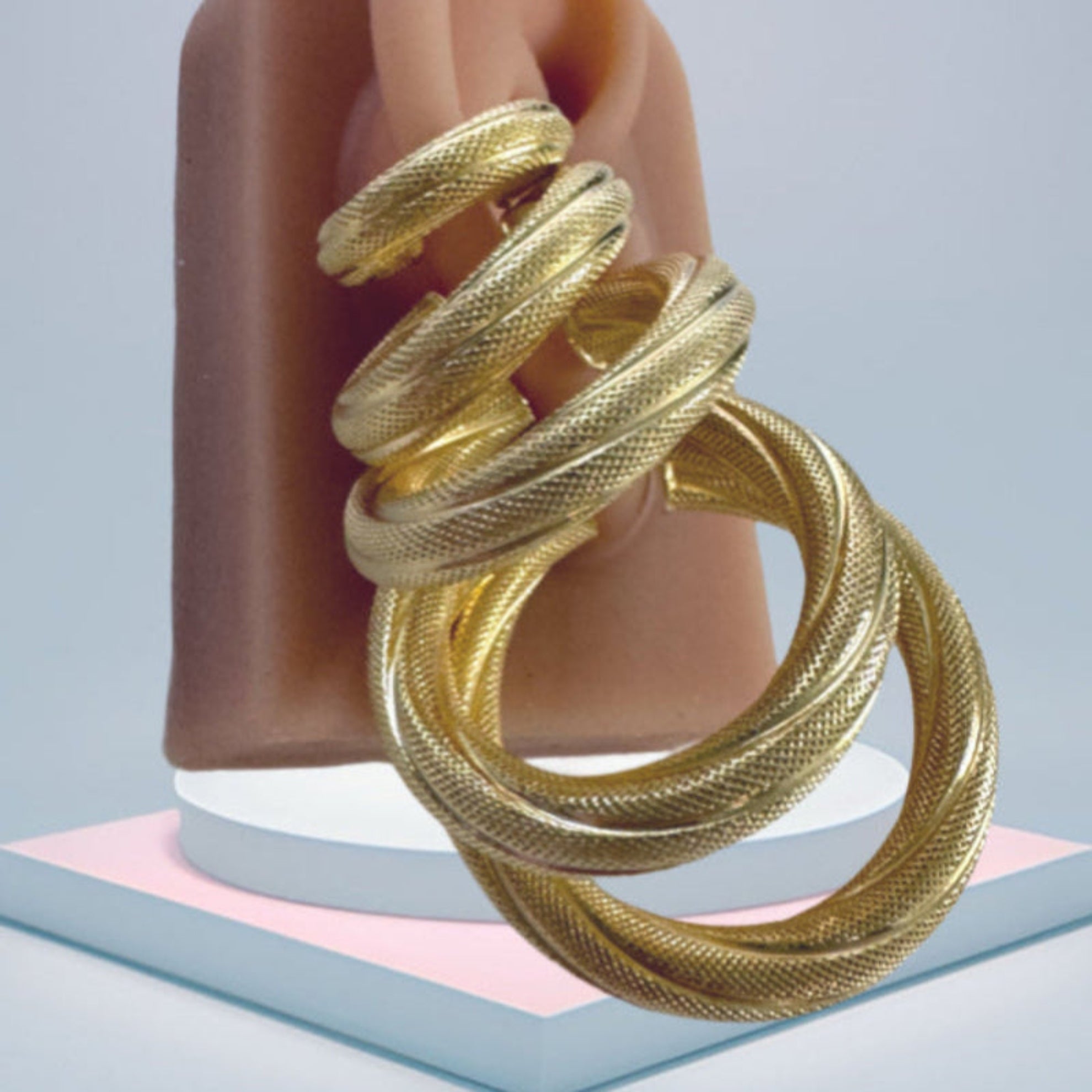 Set de argollas torcidas satinadas en oro 14K con grosor de 6 mm, muestra de tallas variadas para comparar tamaño y estilo