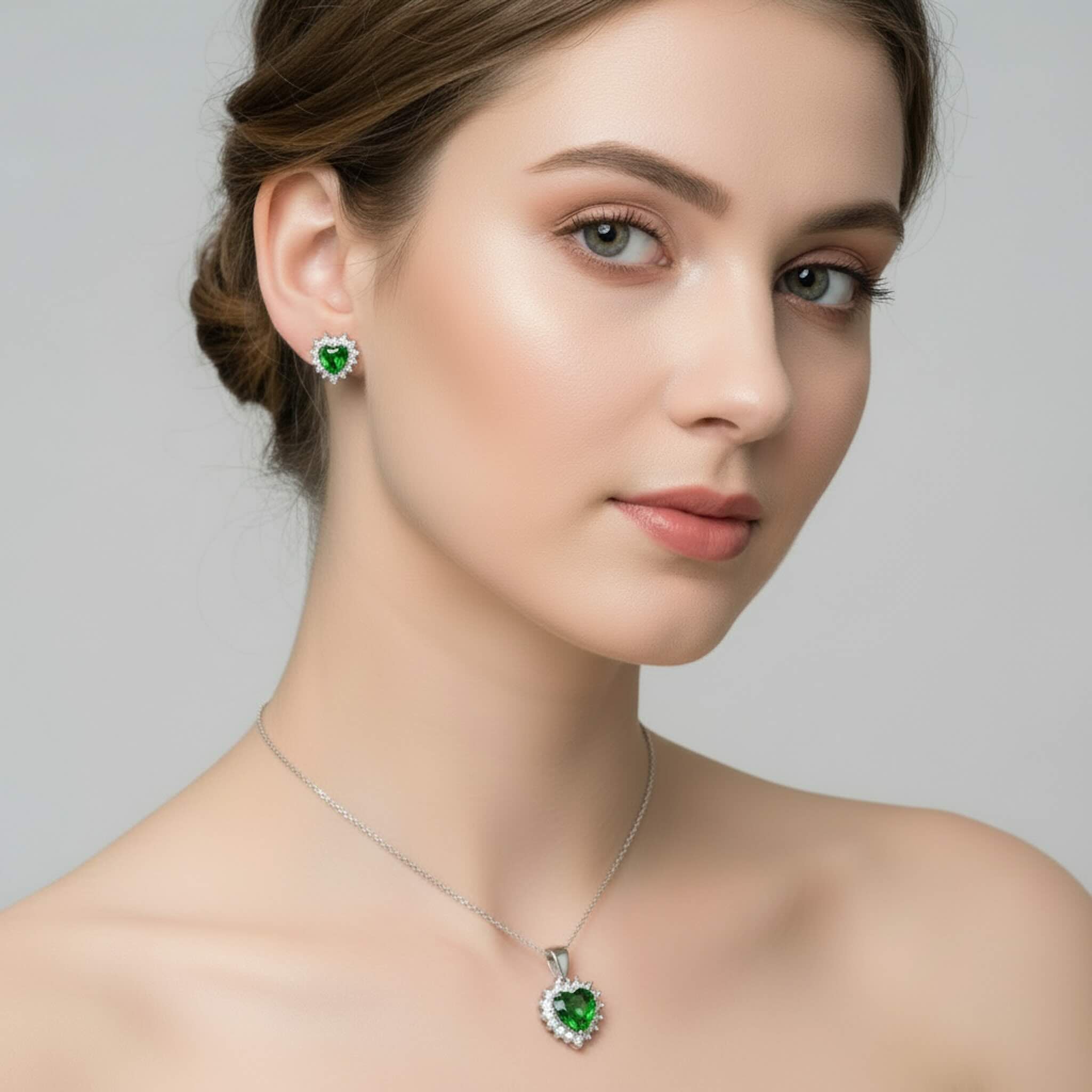 Modelo luciendo el Set de Aretes y Dije en Plata 925 de TuOro con piedra verde en forma de corazón y acabado brillante.