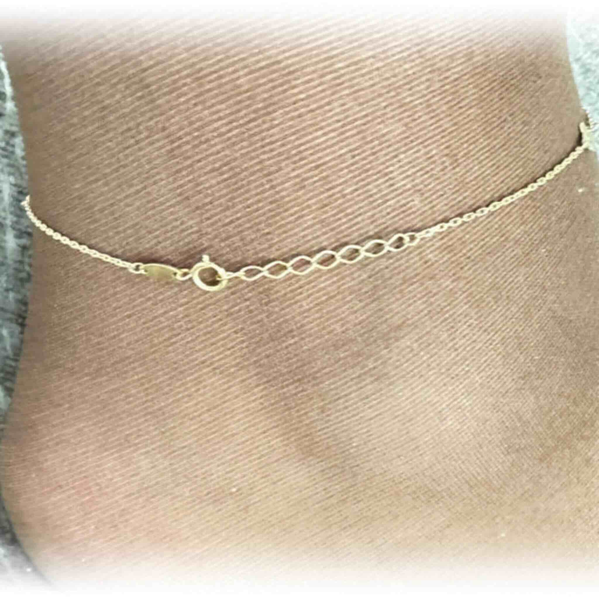 Tobillera fina en Oro 14K mostrando el sistema de ajuste de largo entre 9 y 10 pulgadas, diseño delicado de Joyería TuOro.