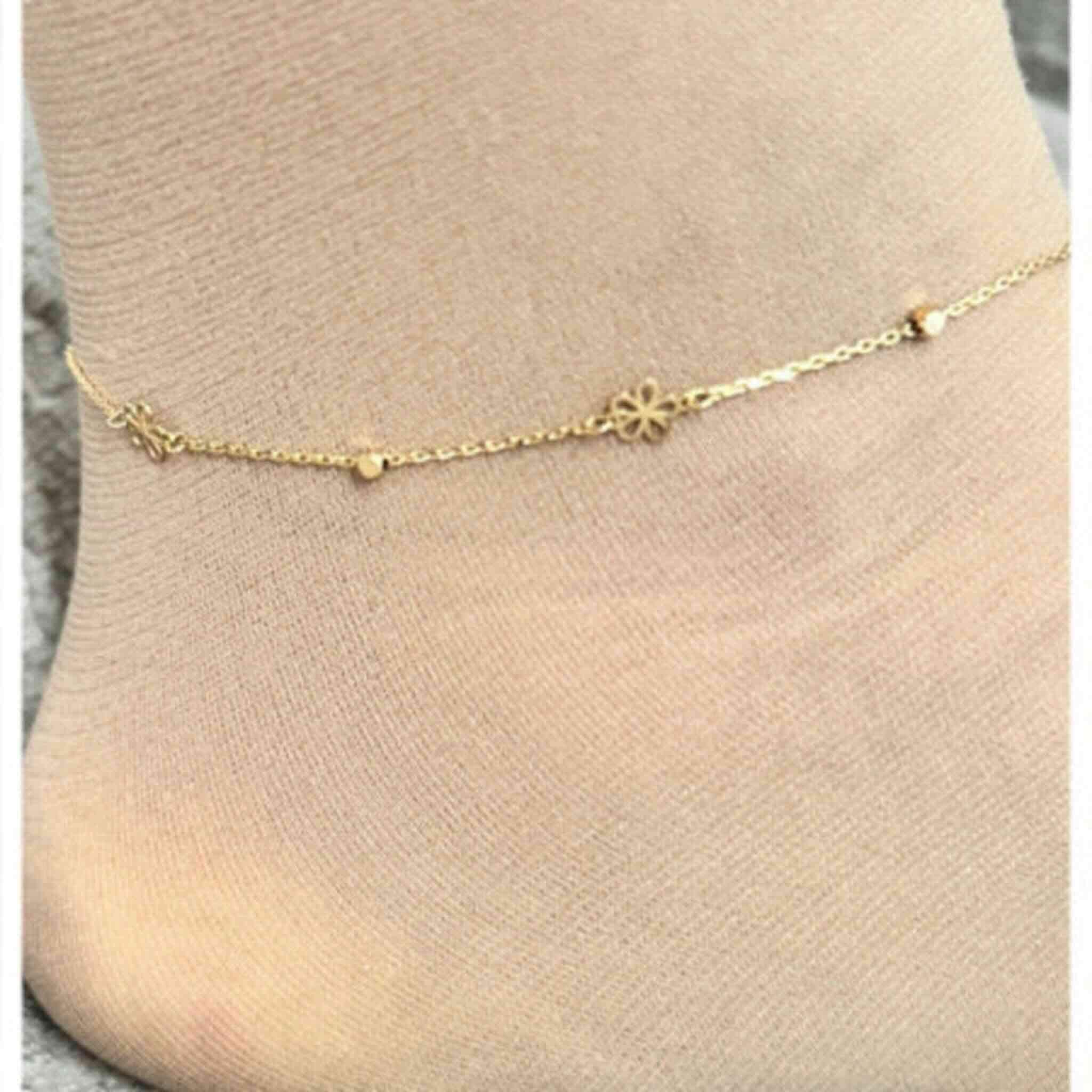 Tobillera fina en Oro 14K con mariposa integrada en la cadena, colocada en el tobillo, diseño delicado de Joyería TuOro.