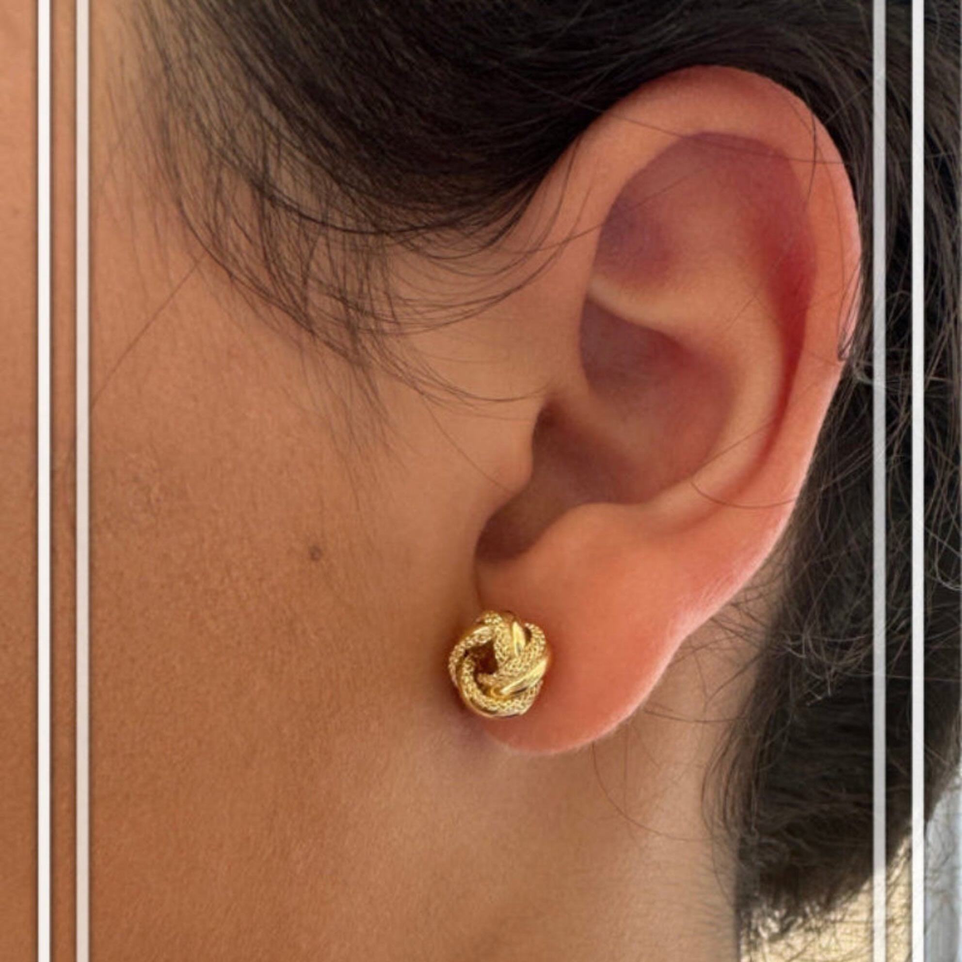 Vista en oreja de aretes Nudo del Amor en oro 14K — tamaño compacto, diseño simbólico, ideal para uso diario

