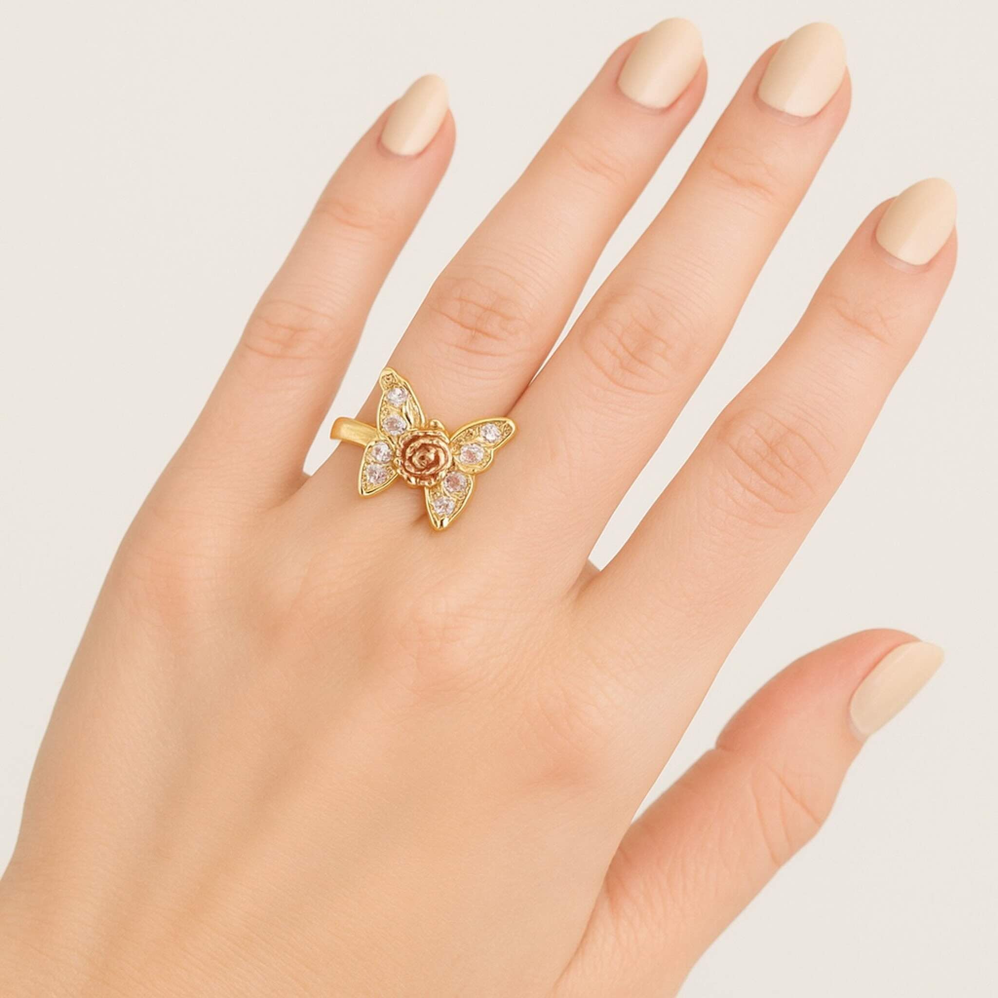 Anillo grueso de Oro 14K con diseño de mariposa y circonias con flor central en mano — TuOro