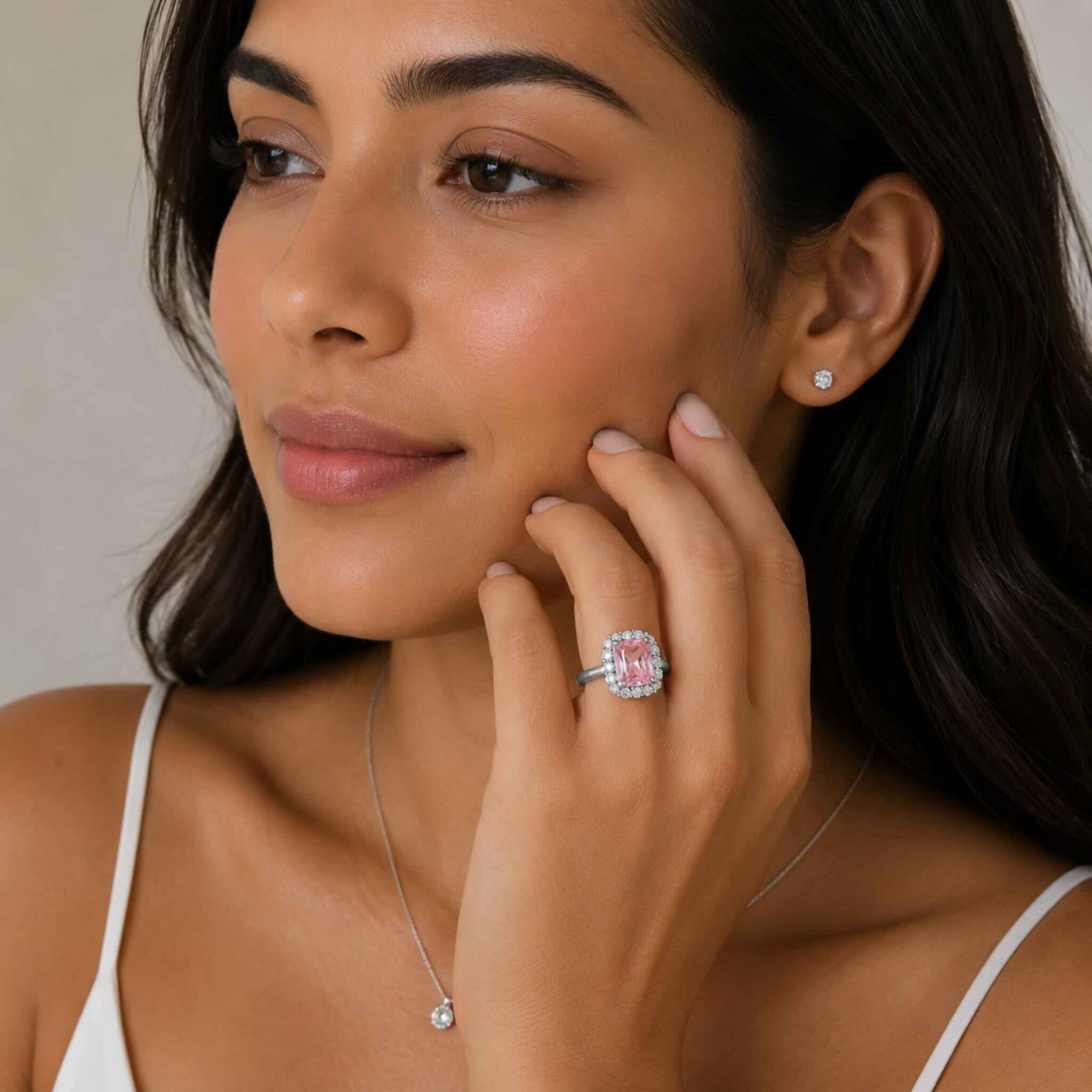 Anillo Rosa Cojín en Plata 925 con circonia rosa central y halo de circonias brillantes de TuOro usado por modelo trigueña.