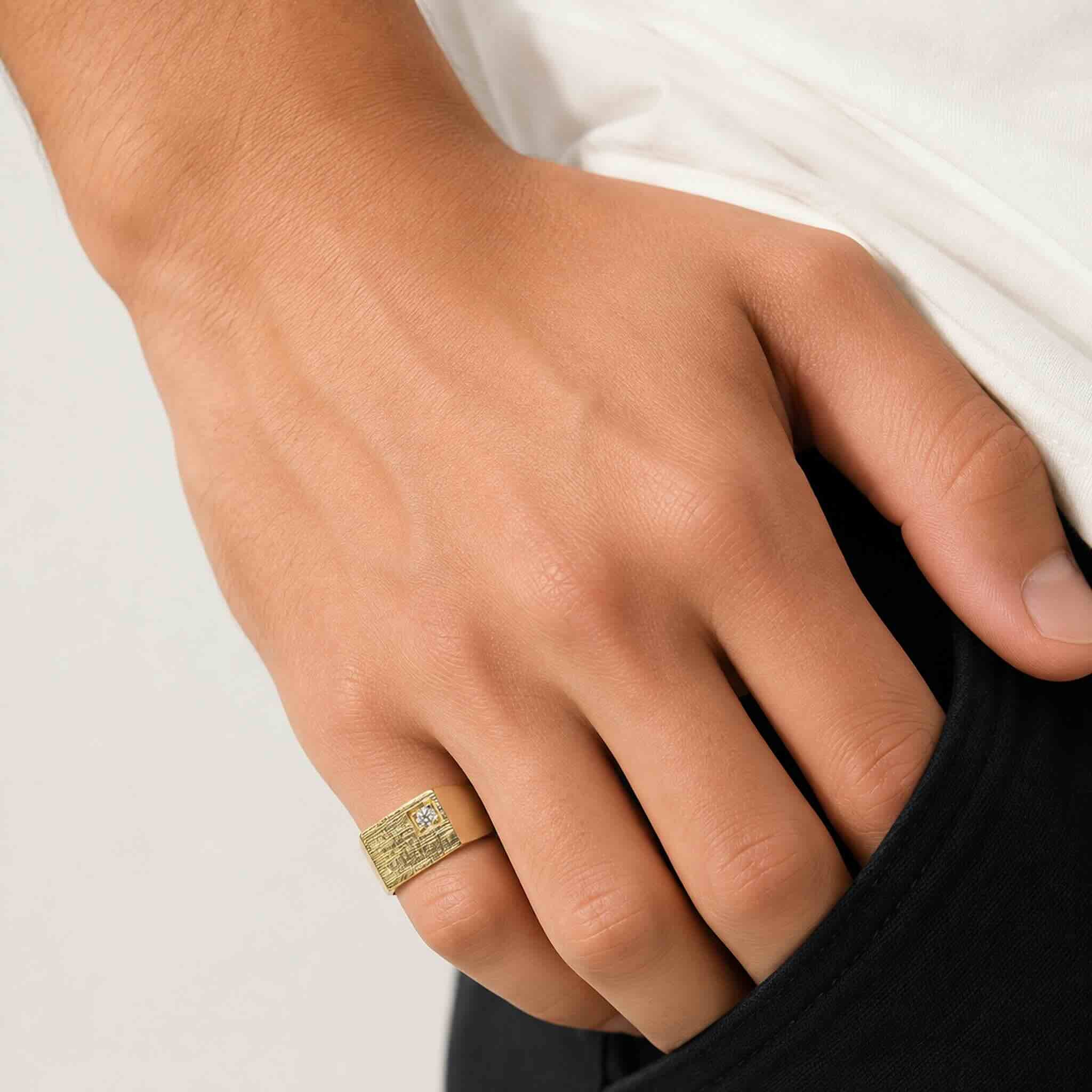 Anillo de Sello para Meñique en Oro 14K de TuOro con textura y circonia, lucido en la mano de un hombre joven, foto de catálogo.