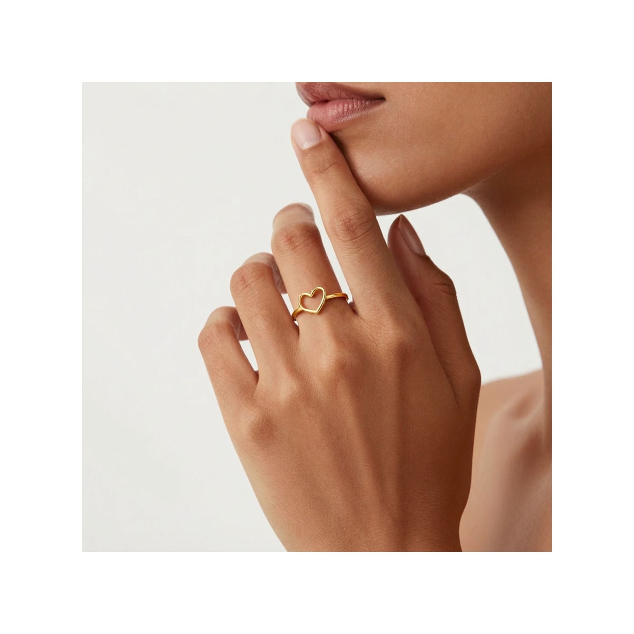 Anillo elegante en Oro 10K de TuOro® con diseño de corazón abierto, puesto en la mano de una mujer joven en una escena elegante.