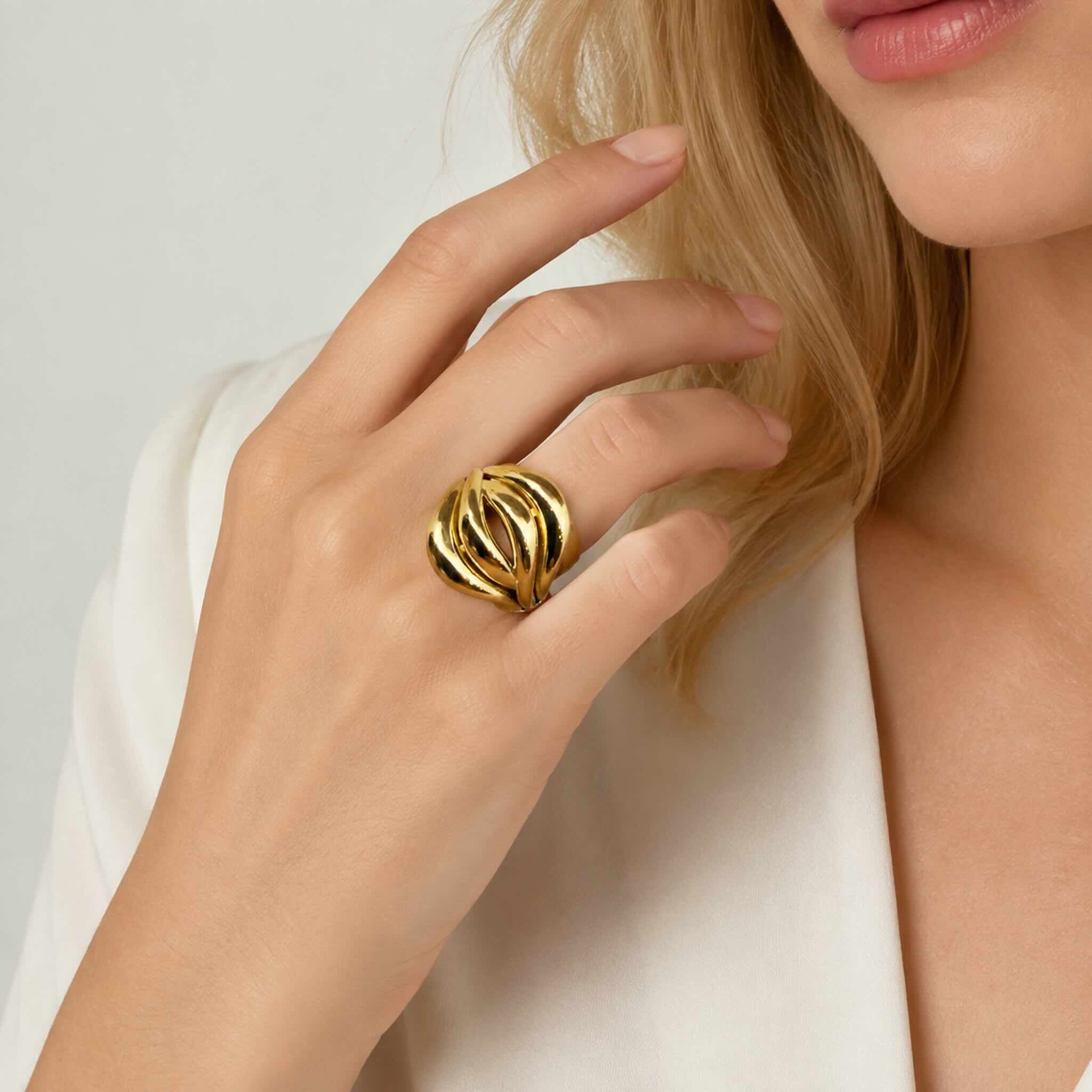 Anillo llamativo en Oro 10K con diseño calado modelado en la mano de una mujer rubia joven, foto de catálogo de TuOro®.