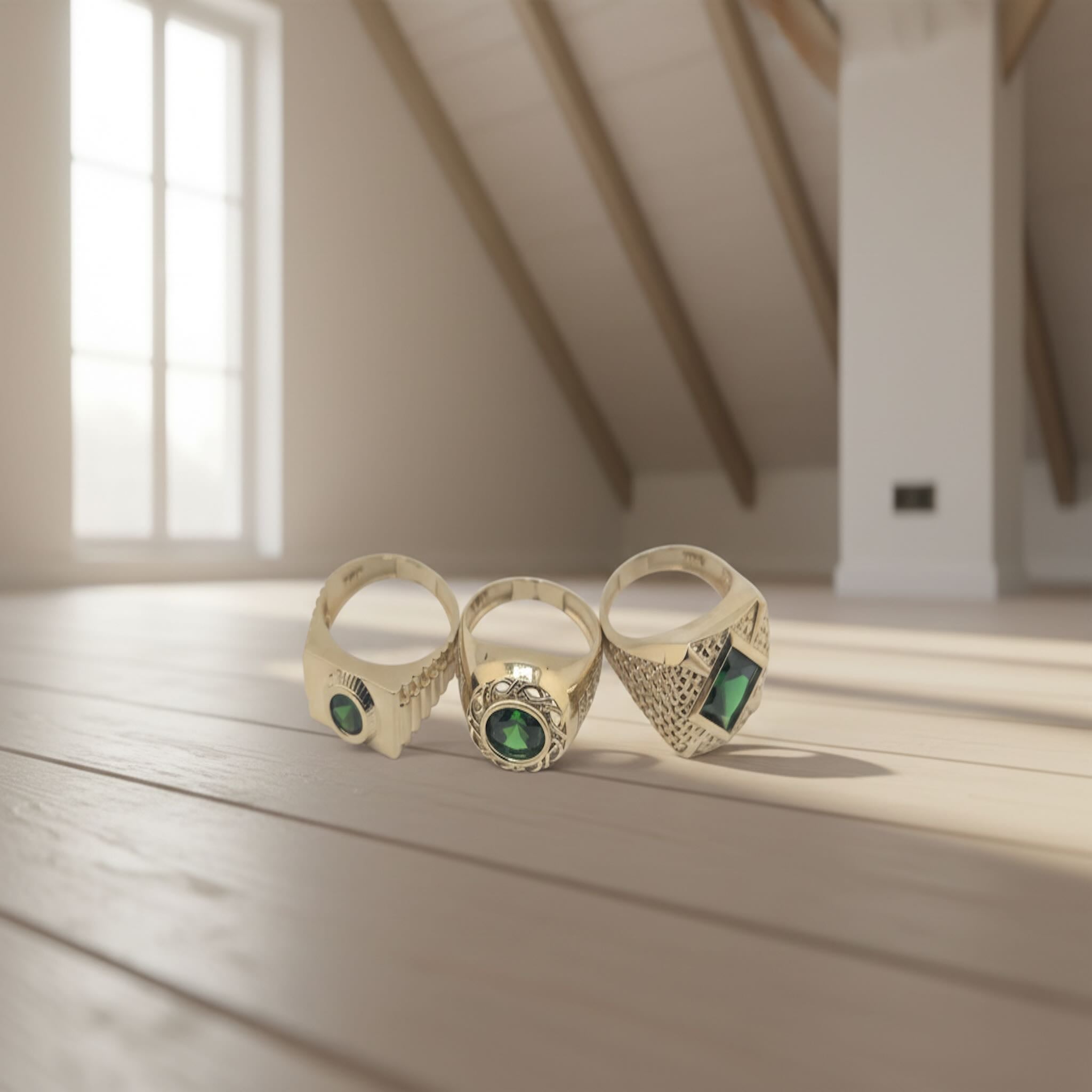 Colección de anillos de Oro 14K con circonia verde sobre mesa de madera - TuOro