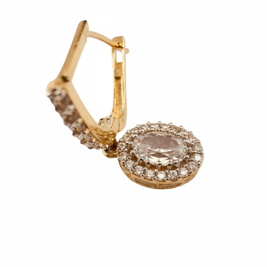 Arete mediano en Oro 14K con cierre catalán y circonia ovalada rodeada de halo brillante.