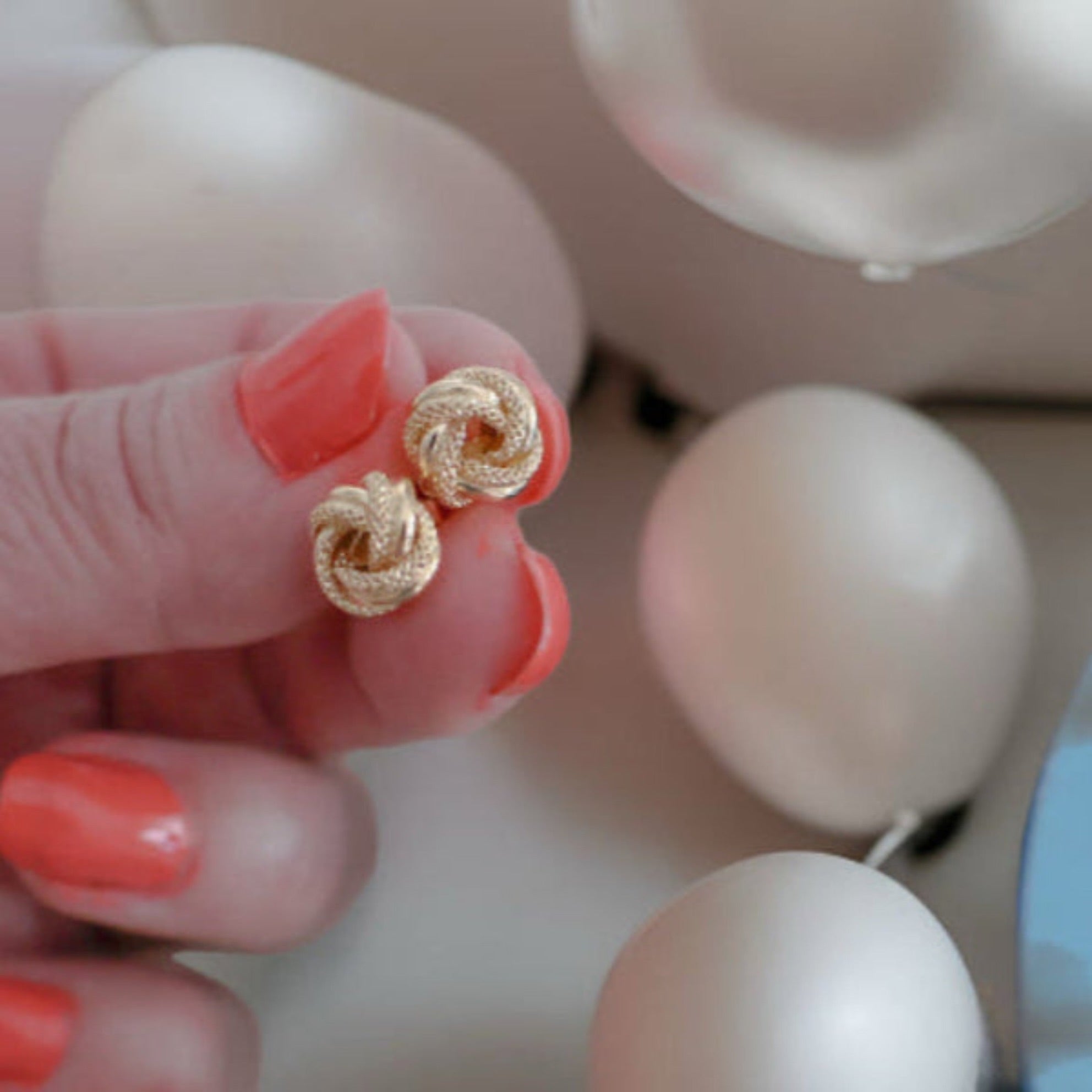 Primer plano de arete Nudo del Amor en oro 14K con diseño entrelazado y combinación de acabados brillante y satinado

