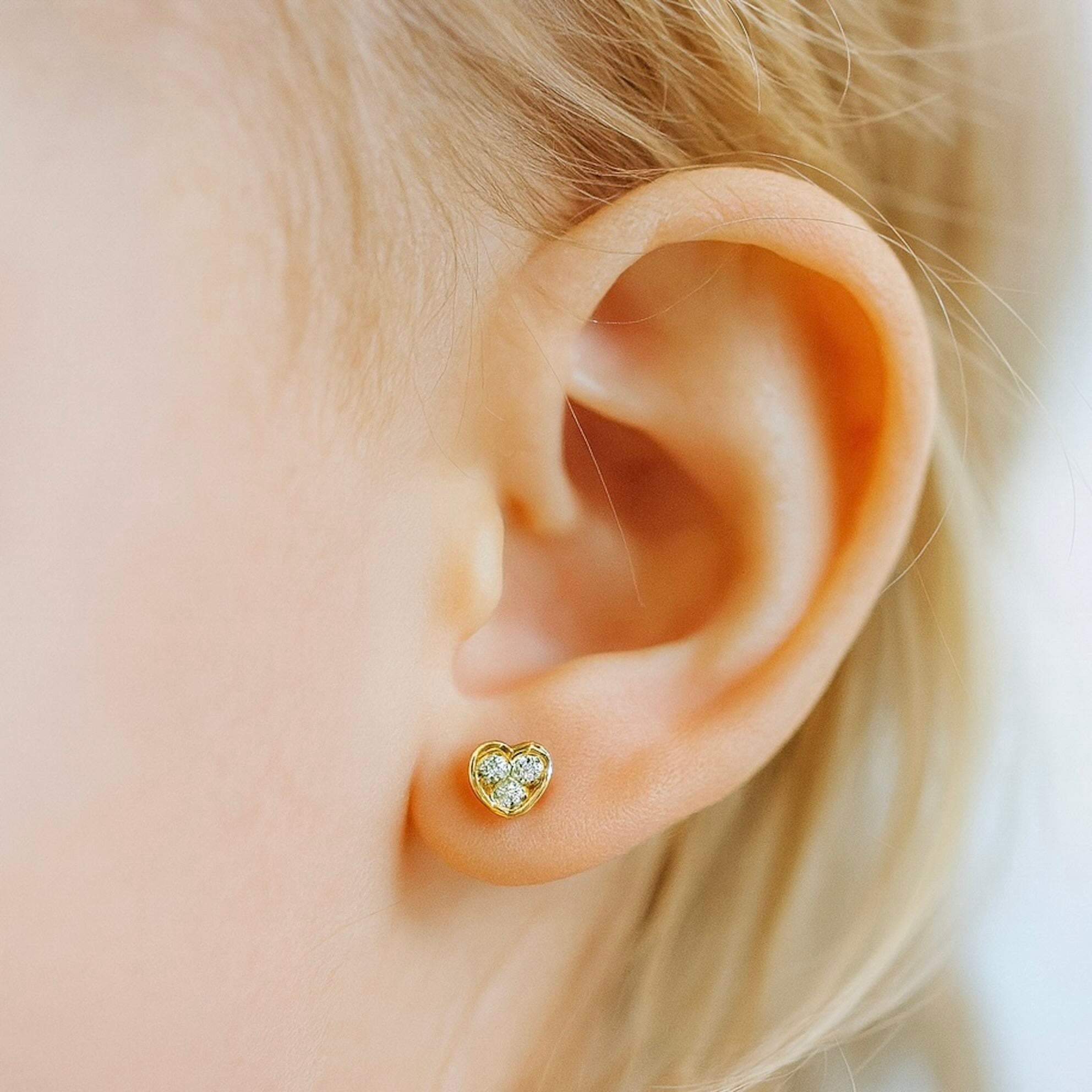 Aretes pequeños en forma de corazón con circonia en oro 14K y cierre mariposa, joyería fina para uso diario.

