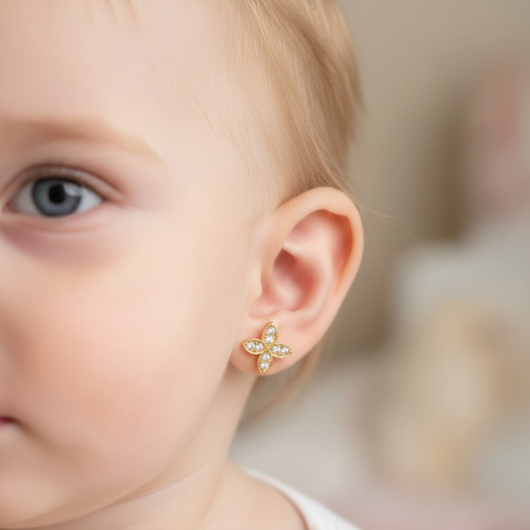 Arete pequeño en Oro 10K con cierre de rosca y zirconia, diseño de flor mostrado en la oreja · TuOro