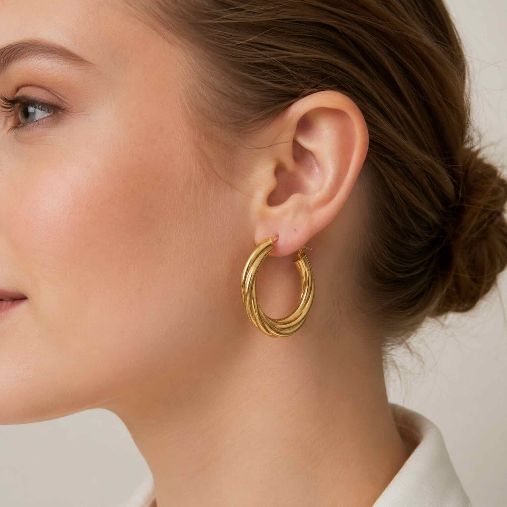 Mujer joven de tez oscura con argollas torcidas lisas en oro 10K de 4.8 mm y 29.5 mm de diámetro
