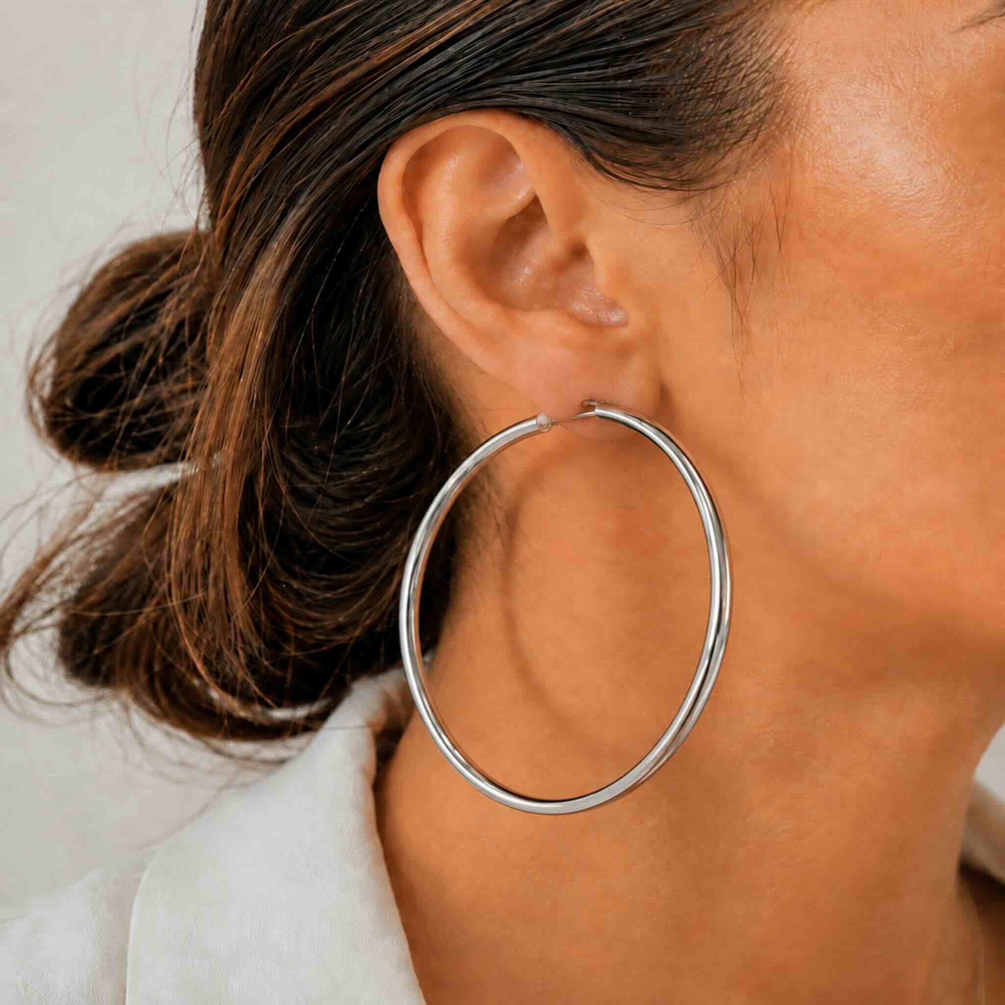 Mujer luciendo argollas tubulares de Plata 925 de 3 mm con diseño clásico y elegante de TuOro.