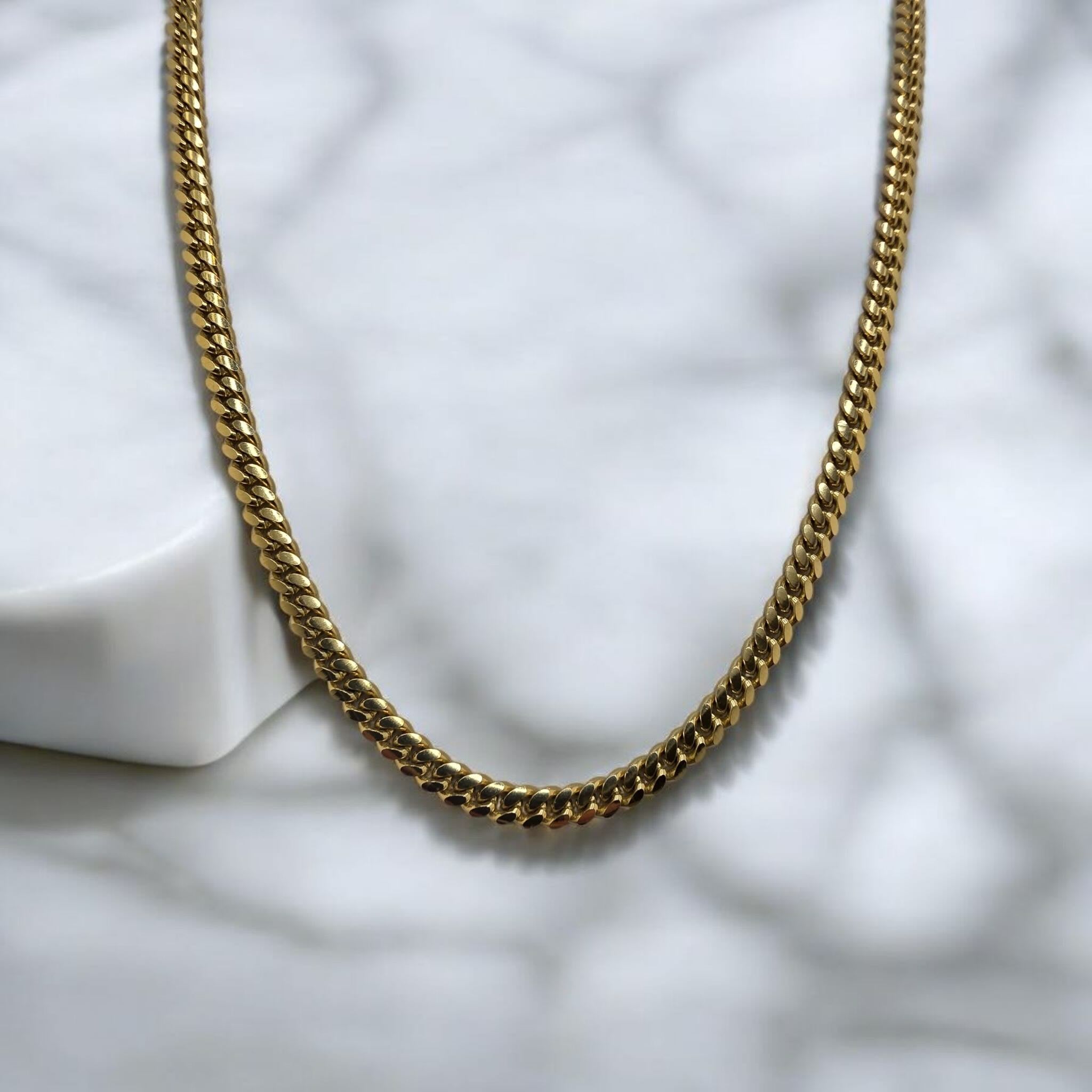 Cadena con cierre de caja en Oro 10K Cuban LInk de 5 mm de ancho mostrandose sola con fondo. TuOro.