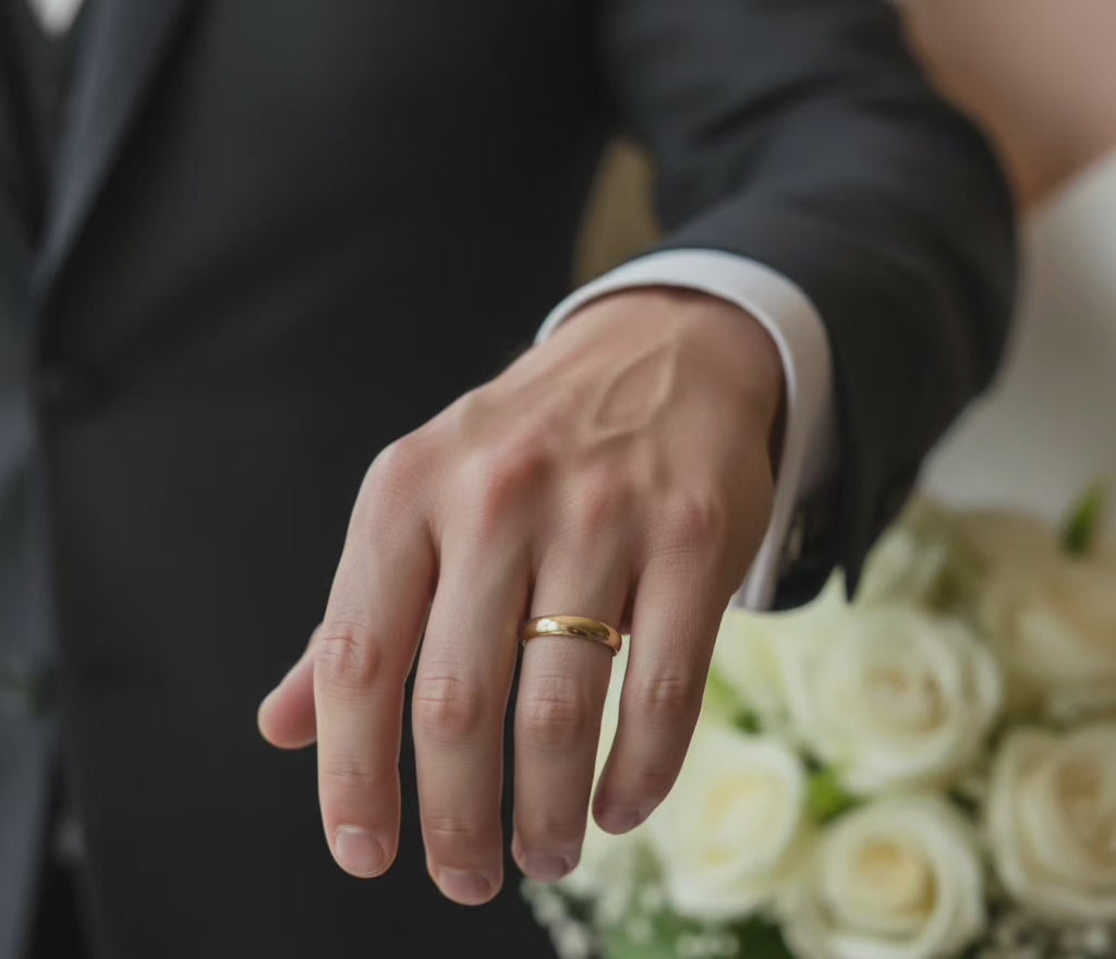 Video corto de Anillos lisos de Oro 14K 3.8 mm TuOro en mano de hombre con traje elegante mostrando uso formal como alianza de boda