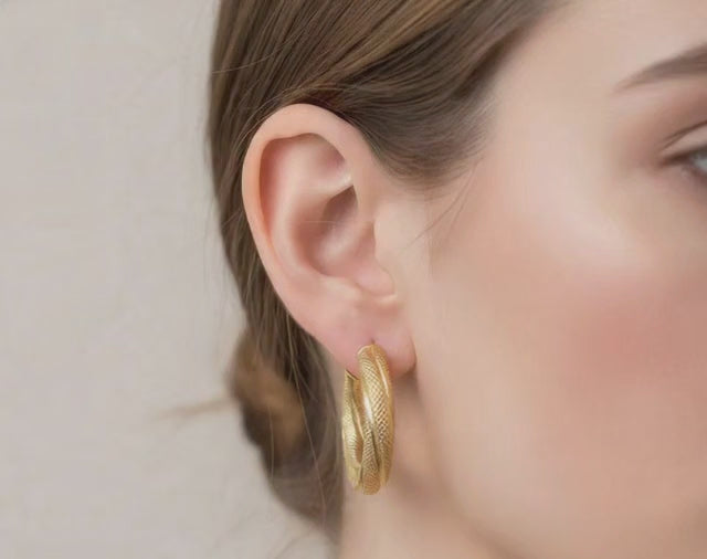 video modelo mostrando aretes estilo argolla en las orejas 