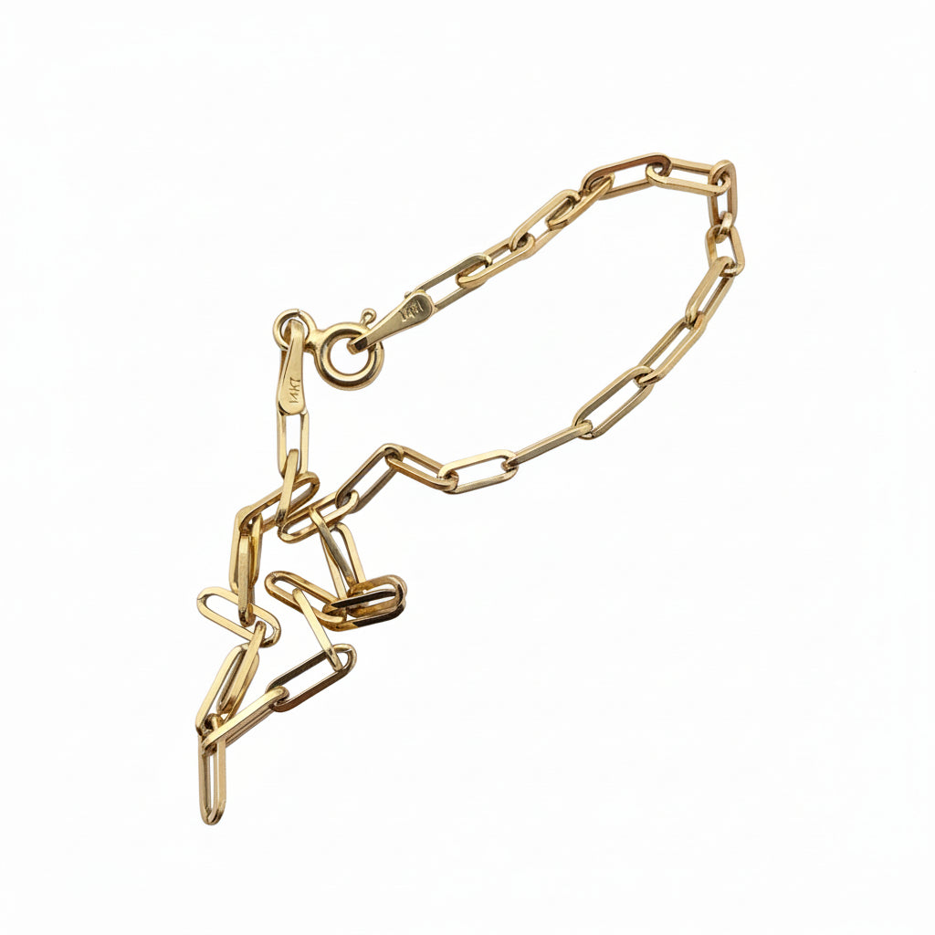 Pulsera Paperclip en Oro 14K 2.2 mm sostenida en la mano, diseño delicado con cierre de resorte fino – TuOro